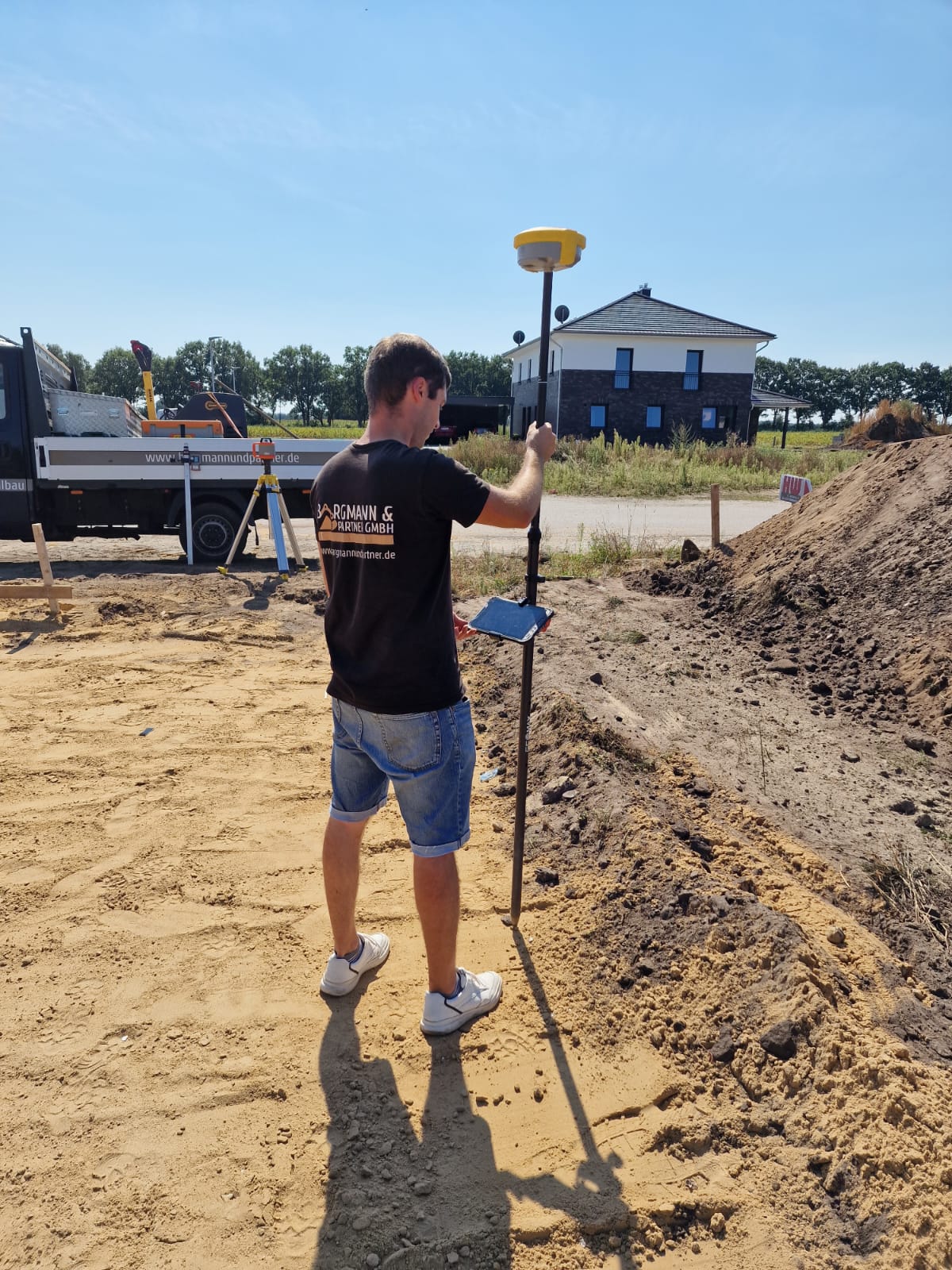 Mitarbeiter bei Vermessungsarbeiten auf einer Baustelle
