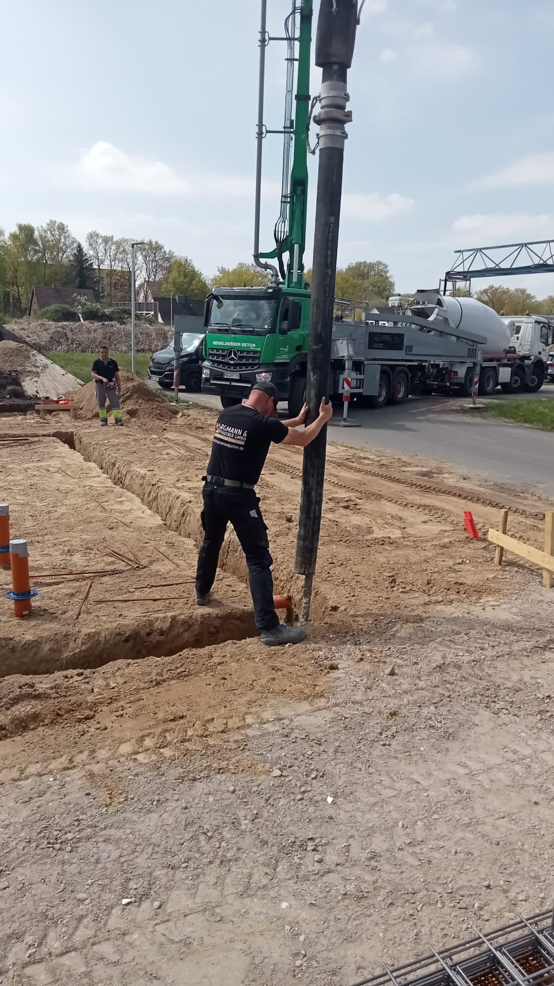 Ein Mitarbeiter führt den Betonschlauch bis in den Fundamentgraben