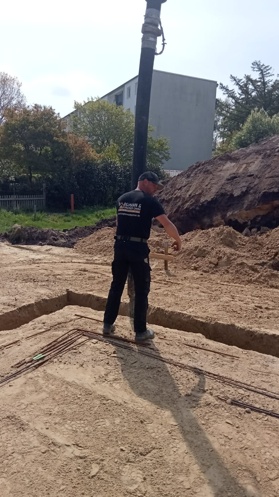 Mitarbeiter neben einer Betonpumpe auf der Baustelle