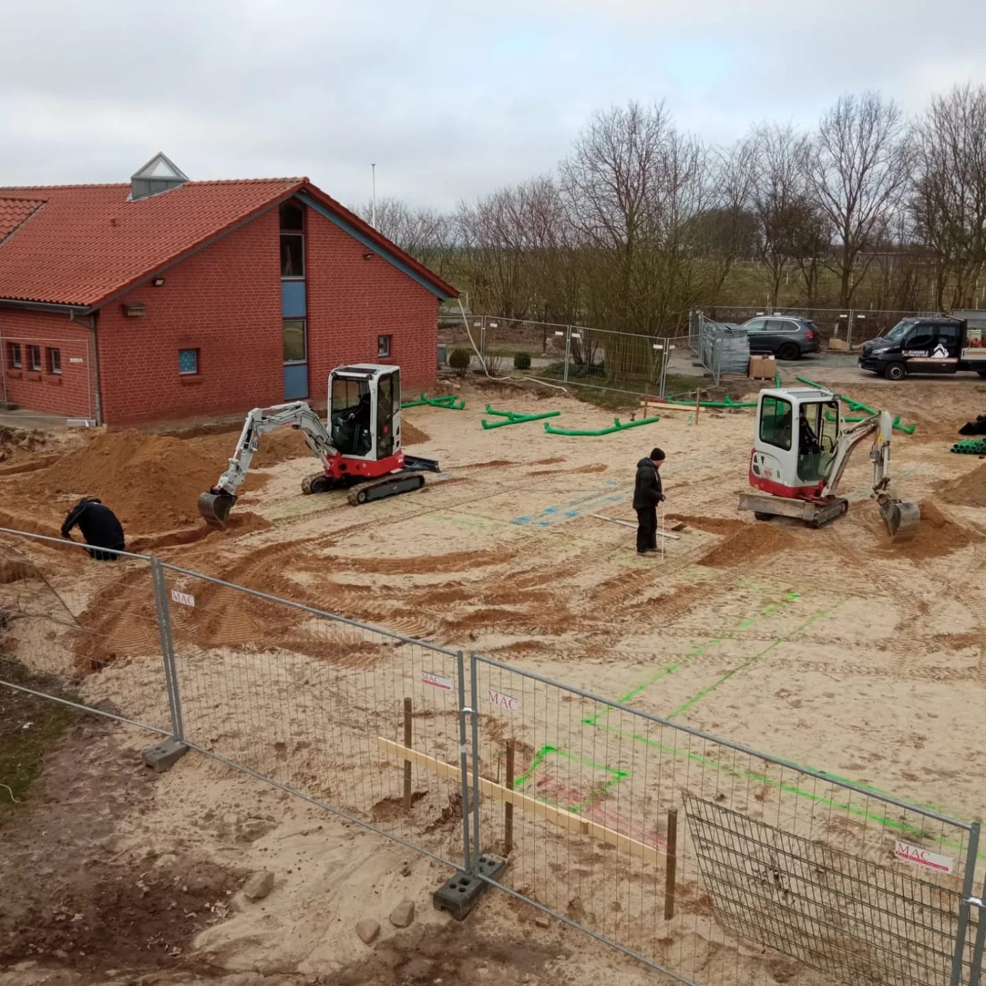 Vorbereitete Baufläche mit Absteckungen neben einem Gebäude