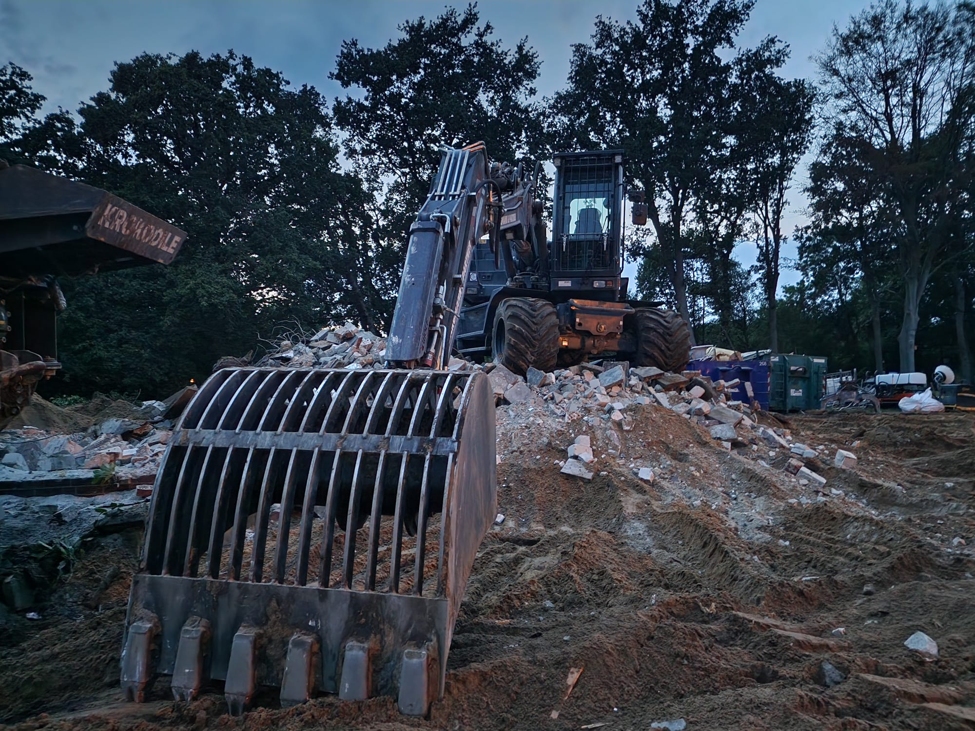 Bagger mit Siebschaufel auf einer Baustelle